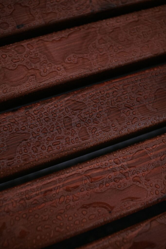 Water droplets beading on brown wood grain